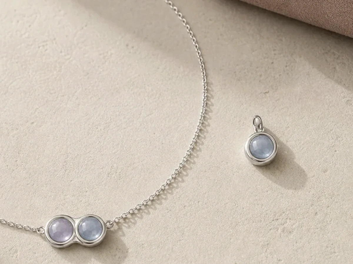 Close-up of the Miorava silver necklace and matching cat Bond Charm